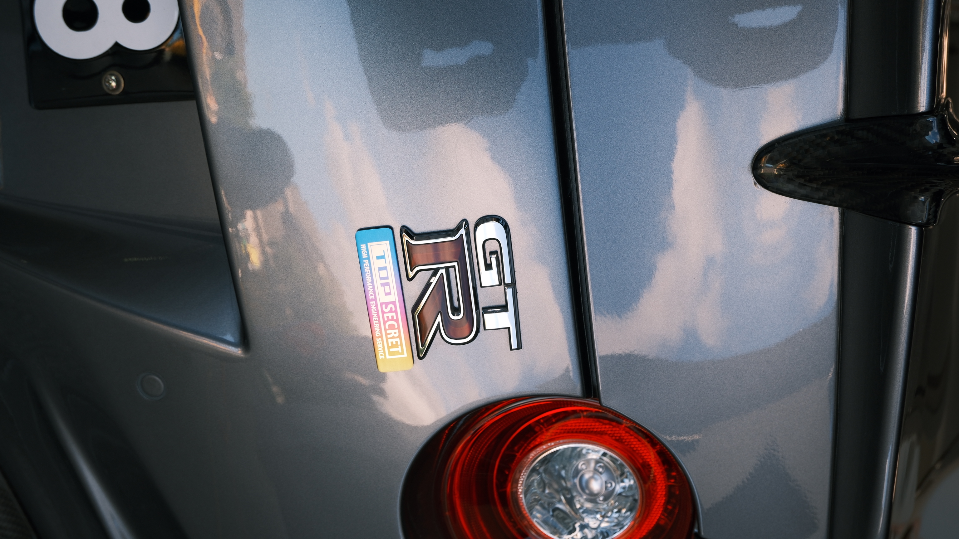 Top Secret Nissan GT-R R35 badge with polished paint reflections