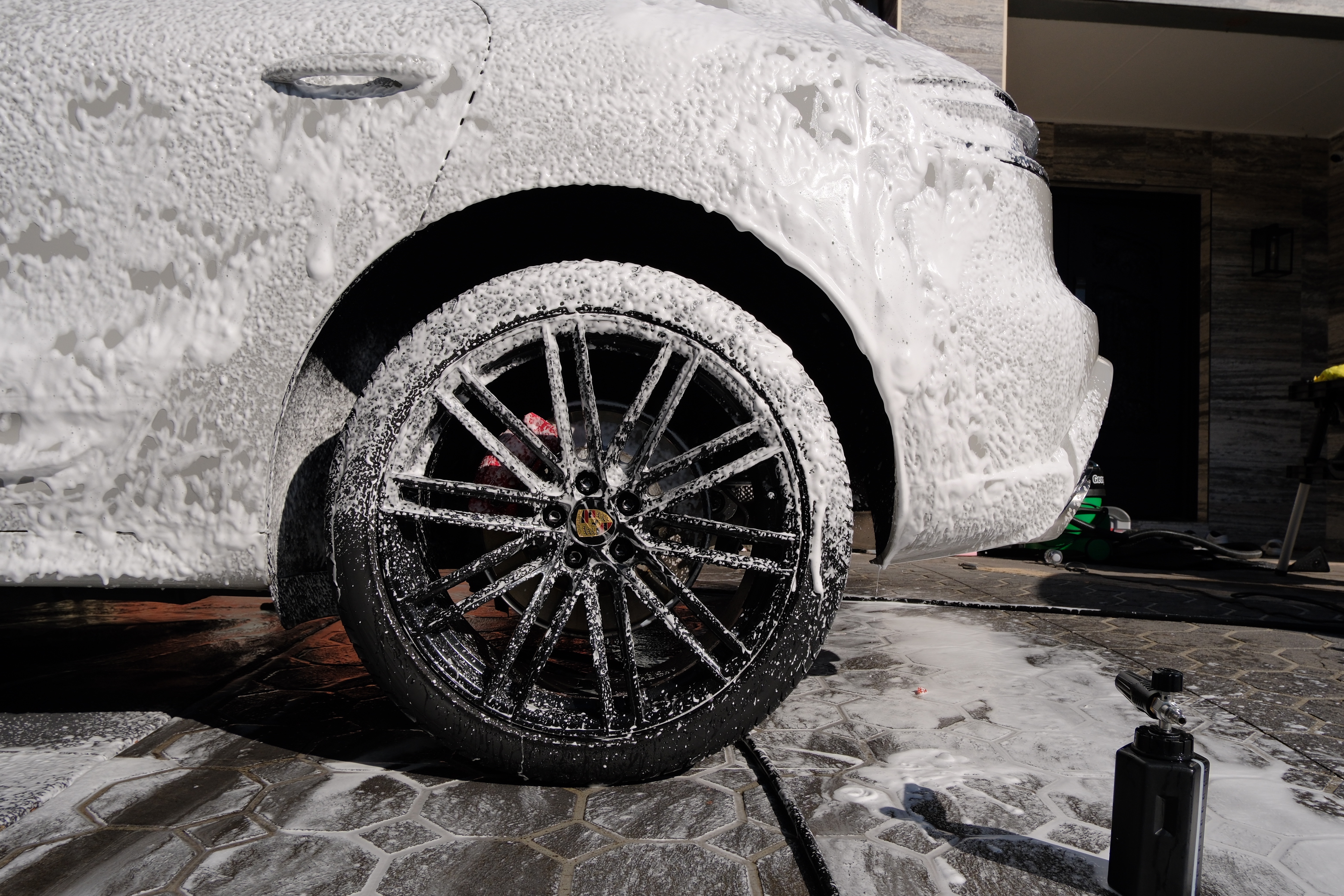 Porsche Macan S wheel and side covered in snow foam
